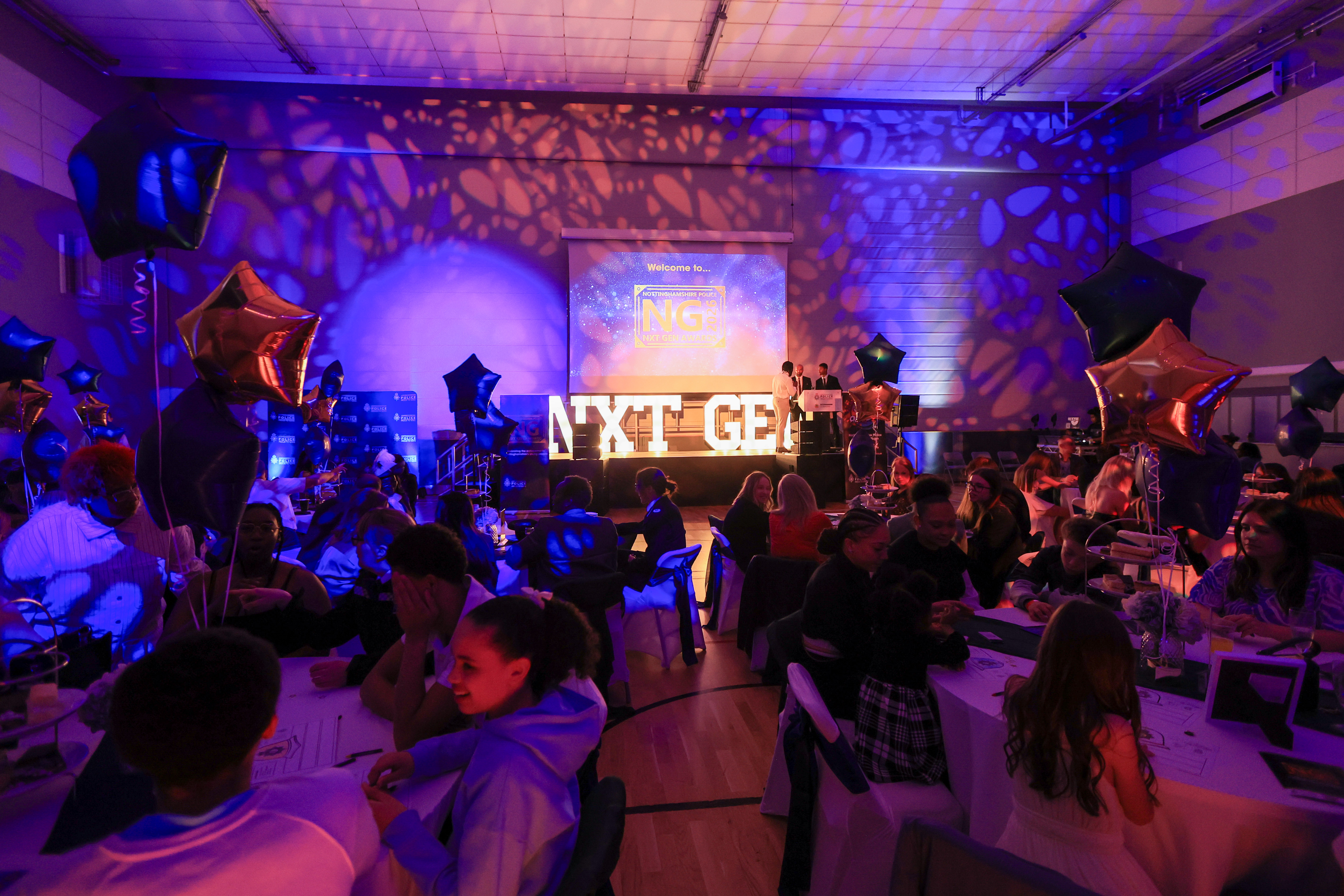 A general view of the Nxt Gen Awards evening with a stage at the front and guests on round tables 