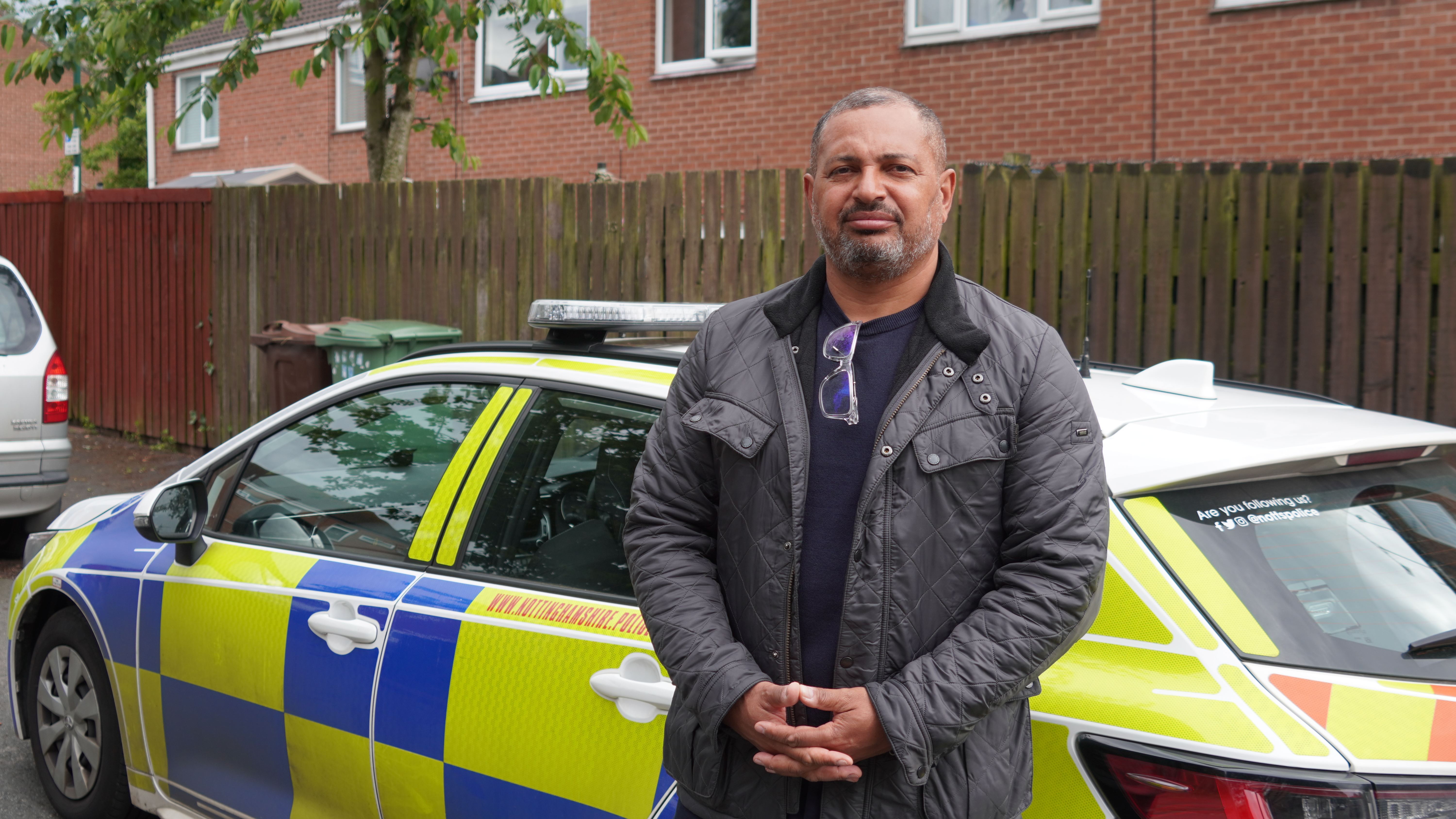 Commissioner Godden standing next to police car