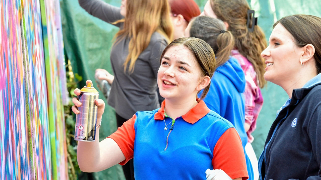 Young people painting wall