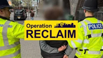 Two officers making an arrest with an Operation Reclaim banner