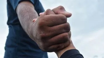 Man holds a hand and helps another man up