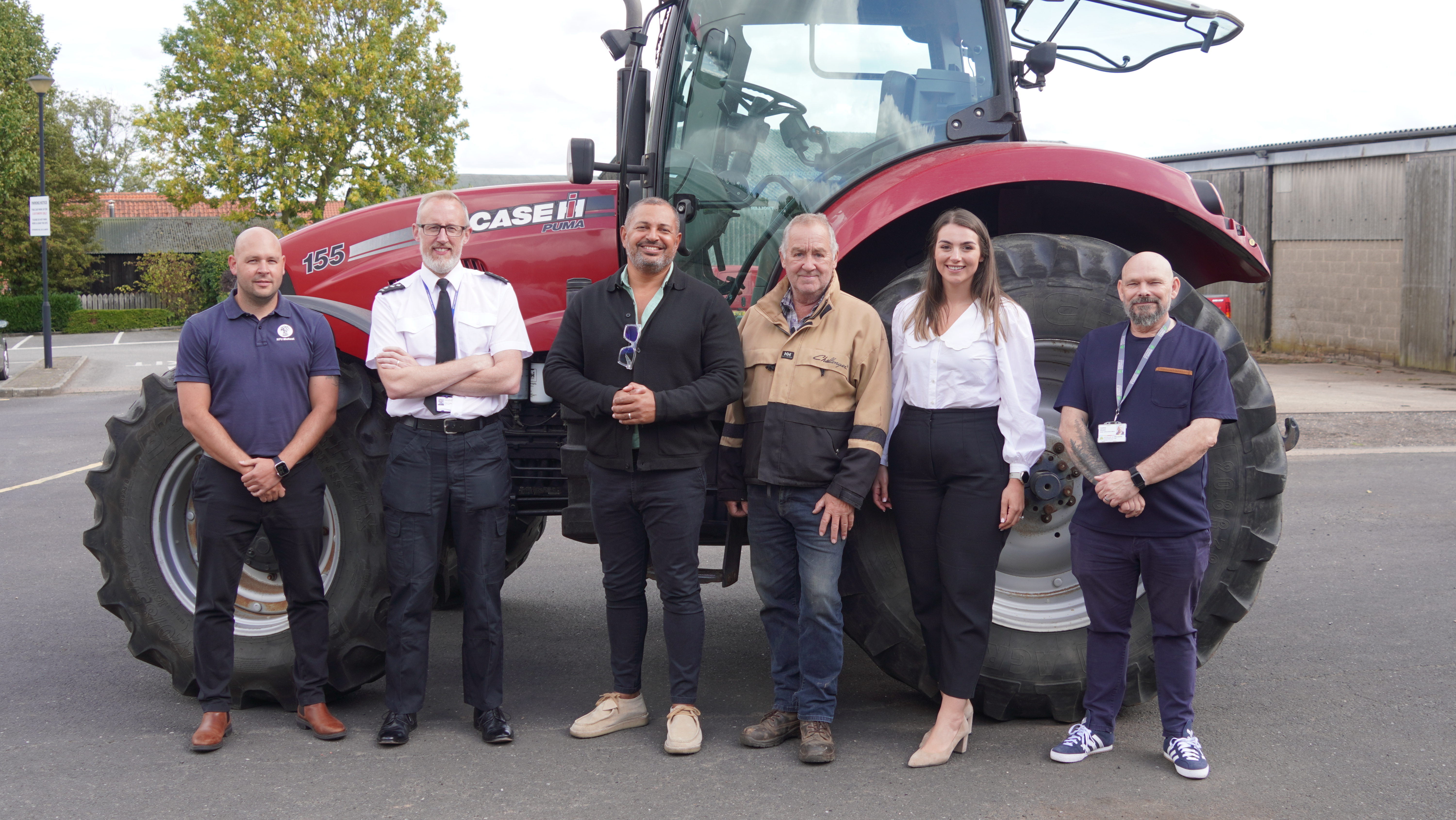 Partners in front of a tractor for the launch of Rural Watch