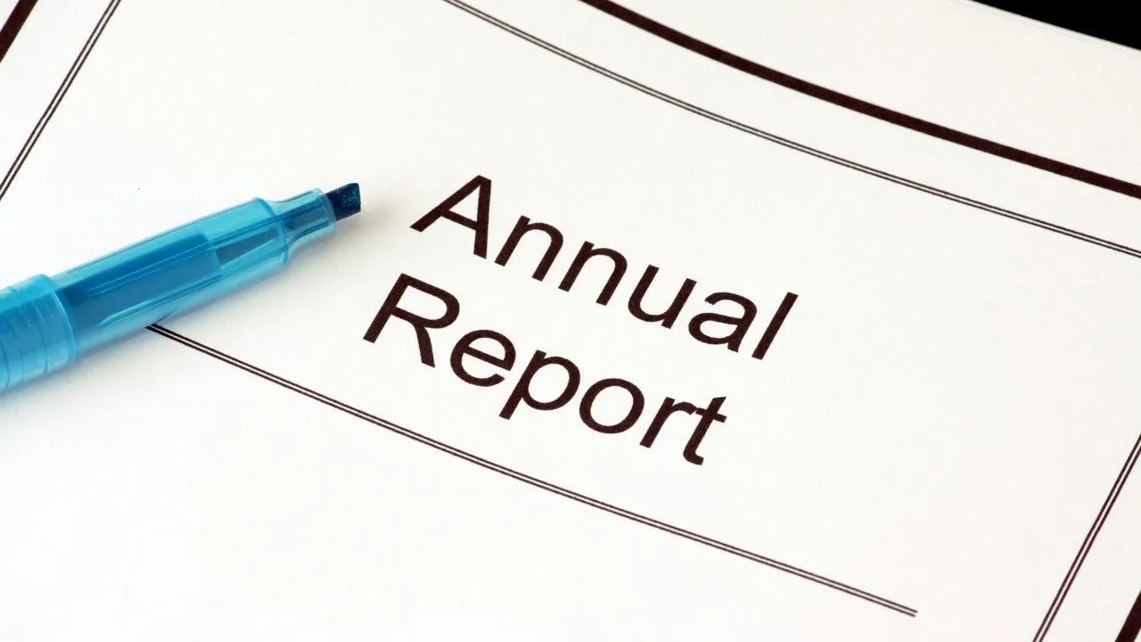 annual report on a desk with blue pen
